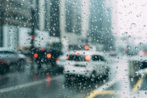 雨粒がついた窓から見える車の列