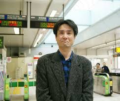駅の改札前で写真を撮る高木啓之