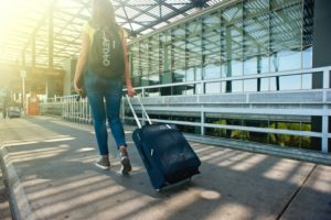 旅行バッグを持って歩く女性の後ろ姿