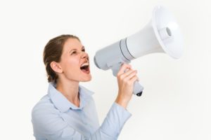 スピーカを持って怒る女性
